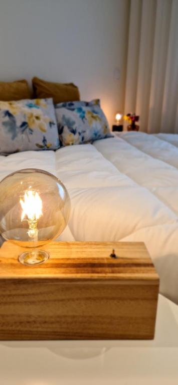 a lamp on a wooden table next to a bed at RAIO FLAT in Braga