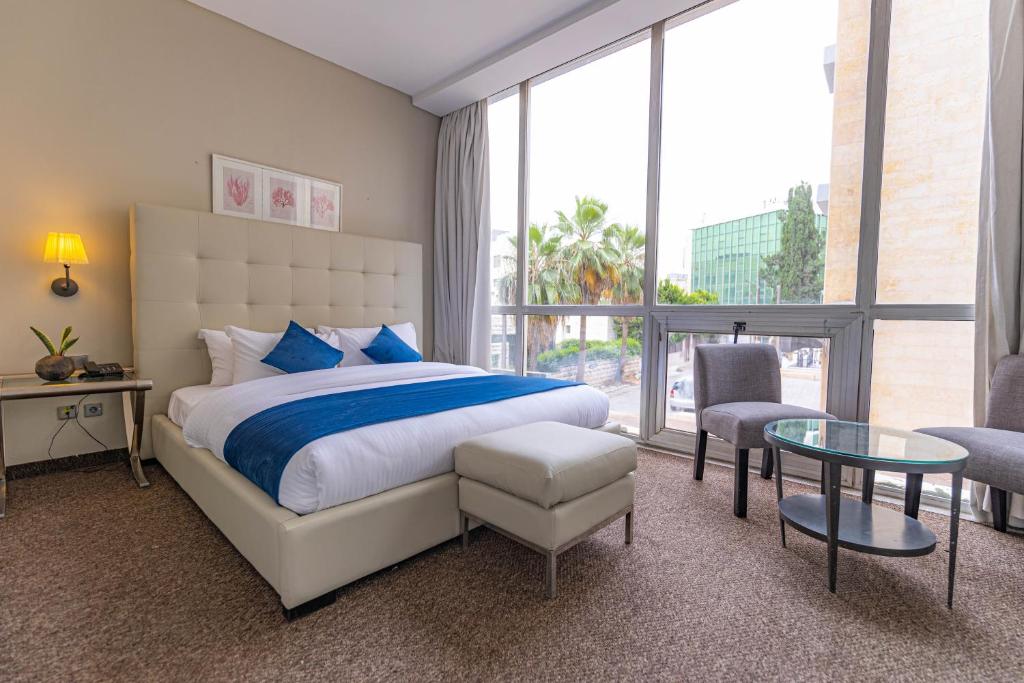 a bedroom with a bed and a large window at Boho Boutique Hotel Amman in Amman