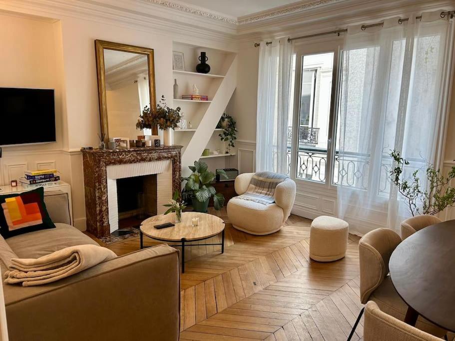 ein Wohnzimmer mit einem Sofa und einem Kamin in der Unterkunft Blanche house près du Moulin rouge in Paris