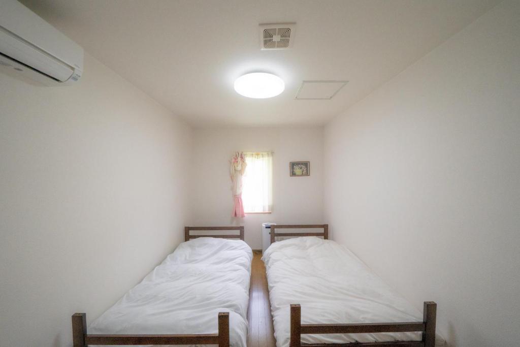 two beds in a small room with a window at Minpaku Ota - Vacation STAY 11962 in Otaru