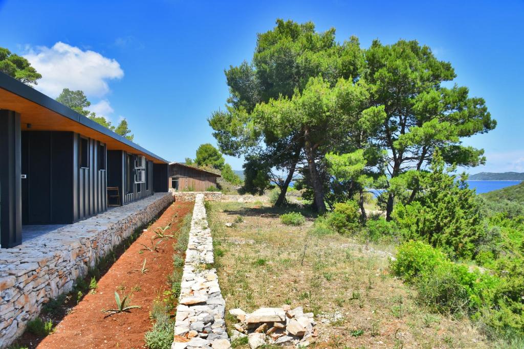 ein Haus mit einer Steinmauer neben einem Gebäude in der Unterkunft Luxury Villa Vela Baraka with Heated Pool in Dragove