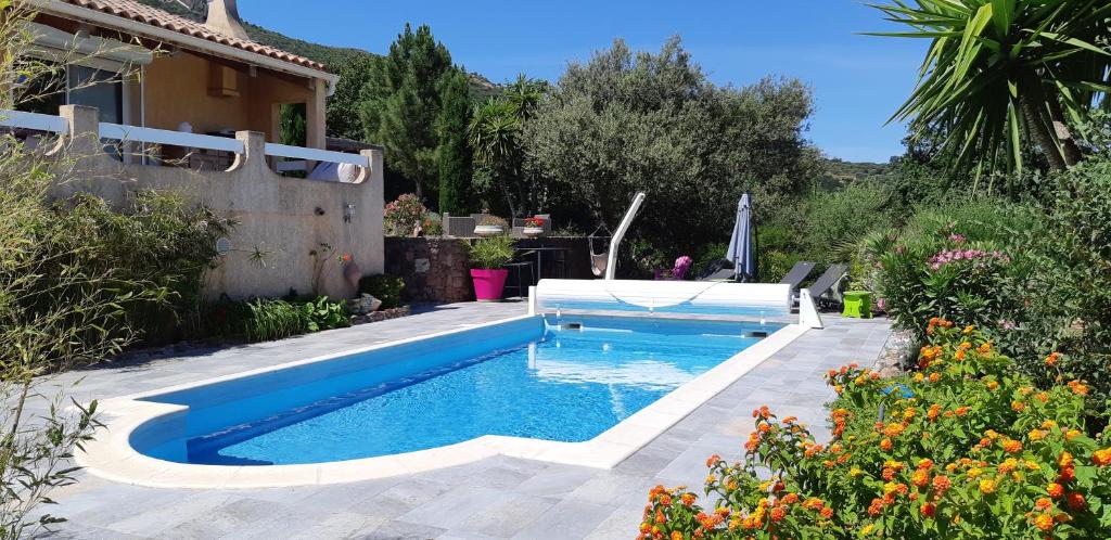 una piscina in un cortile con una casa di Villa Cutalello coté montagne Calenzana a Calenzana