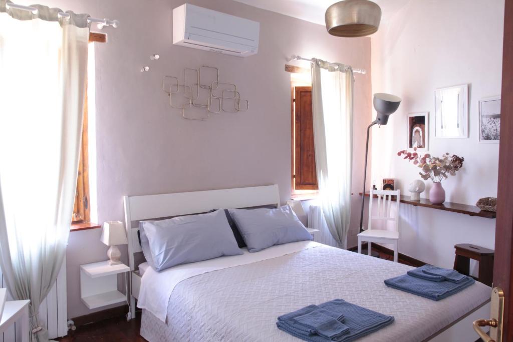 Un dormitorio con una cama blanca con toallas azules. en CIRIBACCO ROOMS, en Macerata