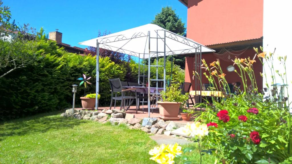 eine Terrasse mit einem Tisch und einem Sonnenschirm im Hof in der Unterkunft Ferienwohnung Hanni in Heringsdorf