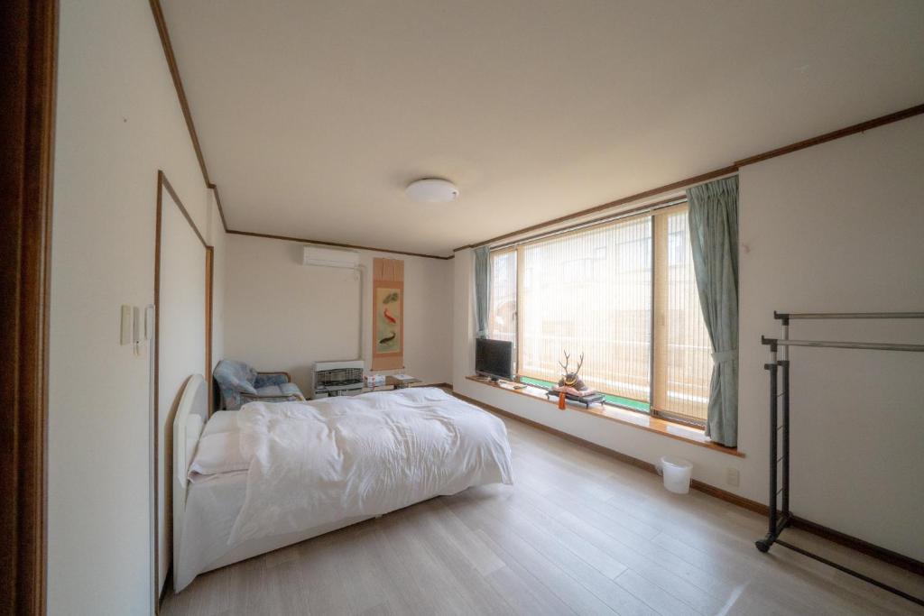 een slaapkamer met een bed en een groot raam bij Ota Building - Vacation STAY 14022 in Otaru