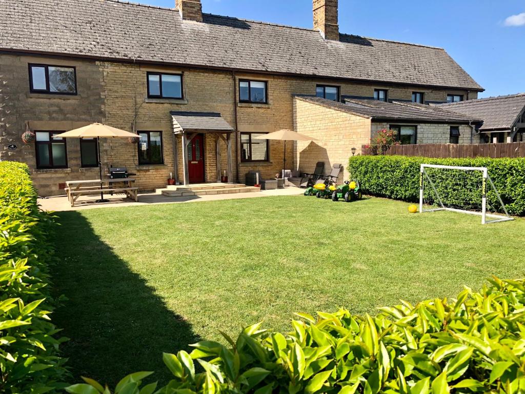 a house with a soccer field in front of it at Moo Cow Cottage Self Catering in Oakham