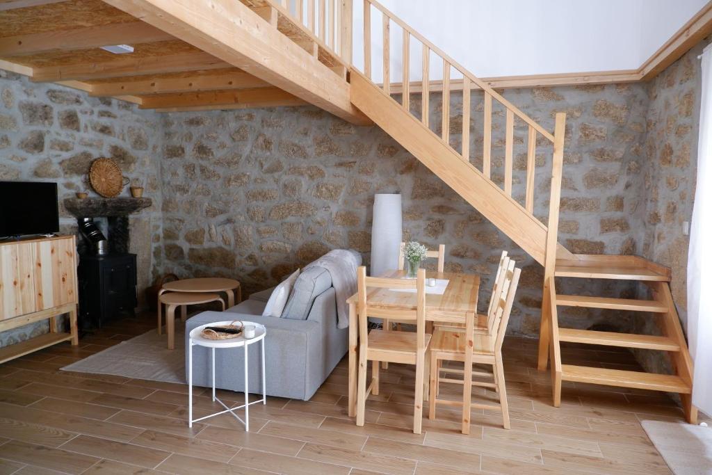 a living room with a staircase and a table and chairs at Casa da Rabita in Capinha