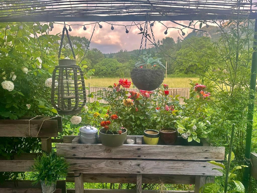 Un jardín con una mesa con flores y una cesta colgante. en la villa provençale, en La Motte-Chalançon