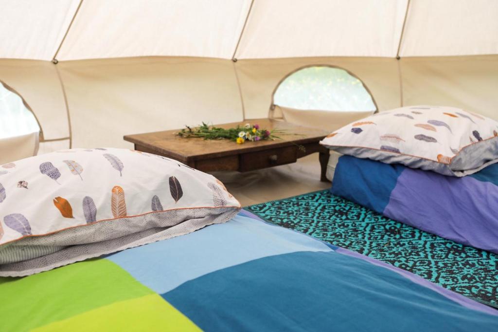 2 Betten in einem Zelt mit Leinwand und Tisch in der Unterkunft Tente style Tepee Confort in Latour-de-Carol