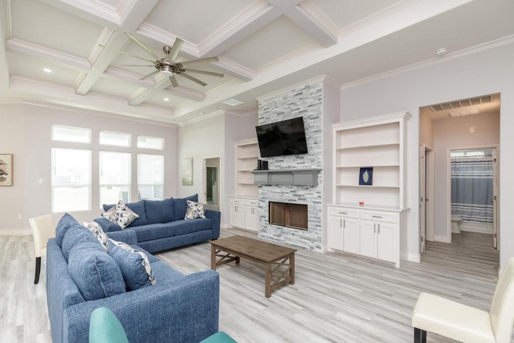 a living room with two blue couches and a fireplace at Luxurious 4-Bedroom Retreat Near the Beach: King Suite, High-Speed WiFi, Free Parking in Corpus Christi