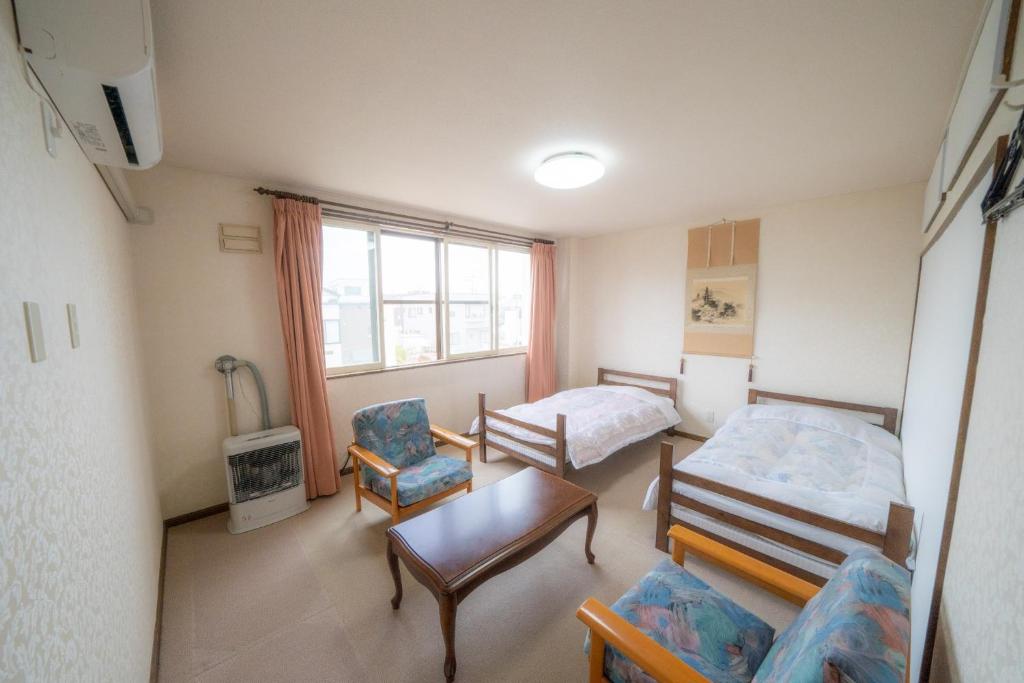 Habitación pequeña con cama y silla en Ota Building - Vacation STAY 13994, en Otaru