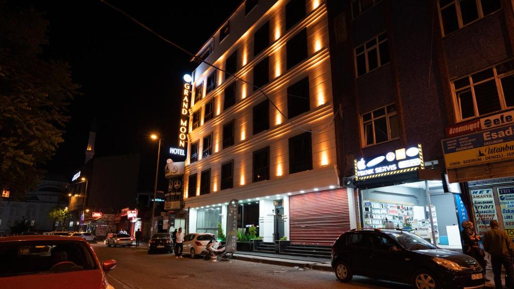 a building on the side of a street at night at GRAND MOON HOTEL in Esenyurt