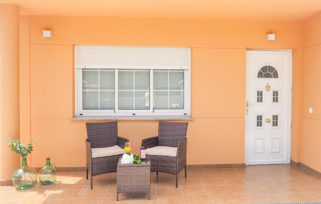 patio z 2 krzesłami, oknem i stołem w obiekcie Casa Rural Horta De Arriba w mieście Porta