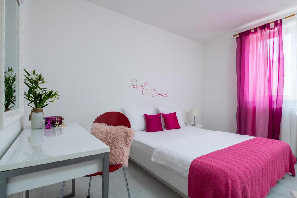 sypialnia z łóżkiem, biurkiem i różowymi zasłonami w obiekcie Apartment Alex w mieście Labin