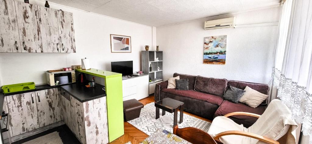 a living room with a couch and a tv at 3pko City center apartment in Banja Luka