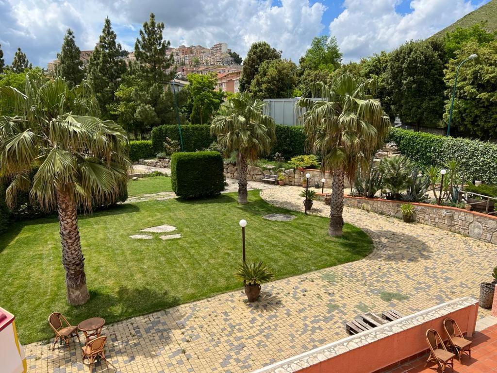 ogród z palmami i trawnikiem z krzesłami w obiekcie B&B PRIXIS w mieście Prizzi