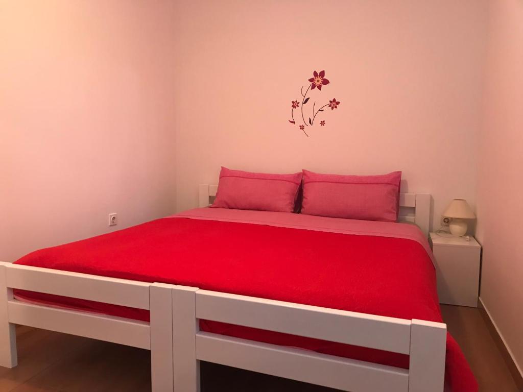 ein Schlafzimmer mit einem großen Bett mit roter Bettwäsche in der Unterkunft Apartment in family house Linda in Čavle