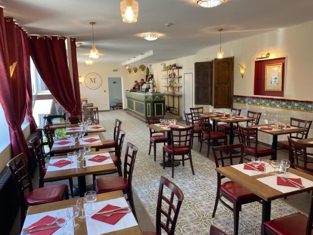 un restaurante con mesas de madera y sillas en una habitación en la madeleine en Saint-Benoît-sur-Loire