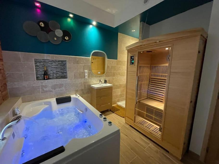 ein großes Bad mit einer Badewanne und einer Dusche in der Unterkunft Suite d'amour et détente jacuzzi, sauna et massage in Chartrettes