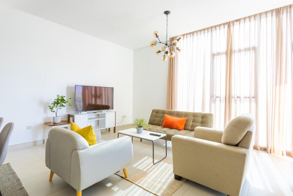 a living room with two couches and a tv at Nasma Luxury Stays - Colorful Condo With Wide City Views From Balcony in Dubai