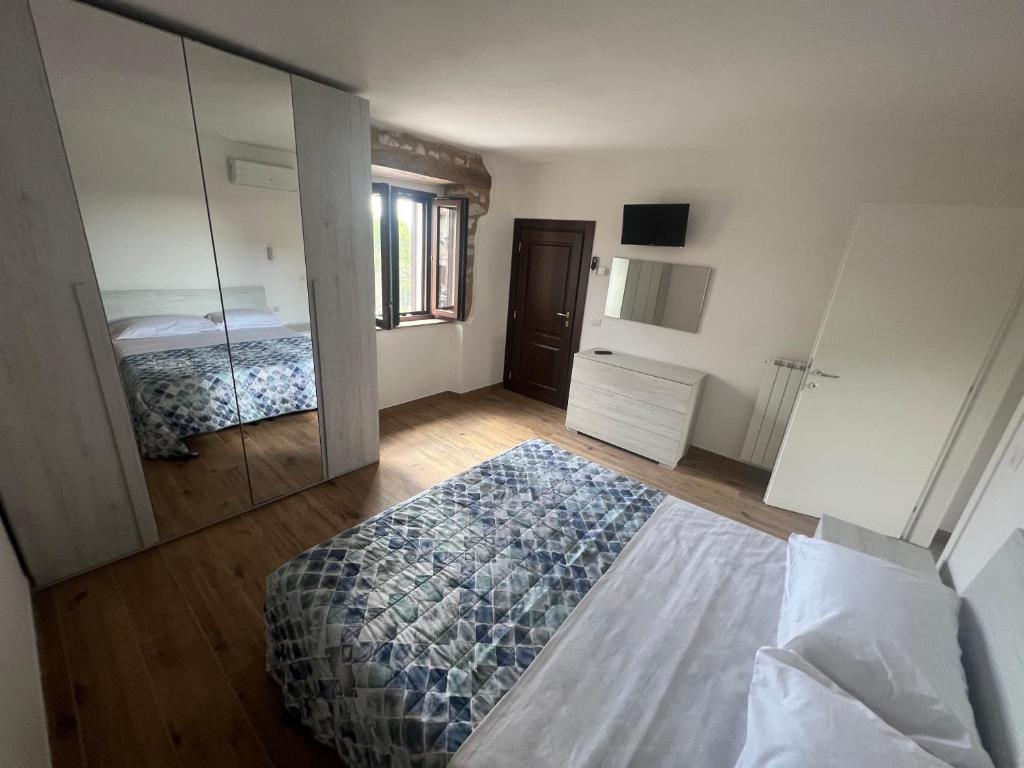 1 dormitorio con cama y espejo grande en Casa Aldobrandeschi Saturnia, en Saturnia