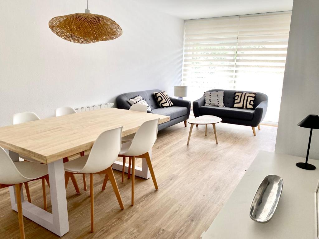 uma sala de estar com uma mesa e um sofá em Apartamento con 3 habitaciones, terraza y jardin comunitario con piscina en Sant Antoni de Calonge em Sant Antoni de Calonge