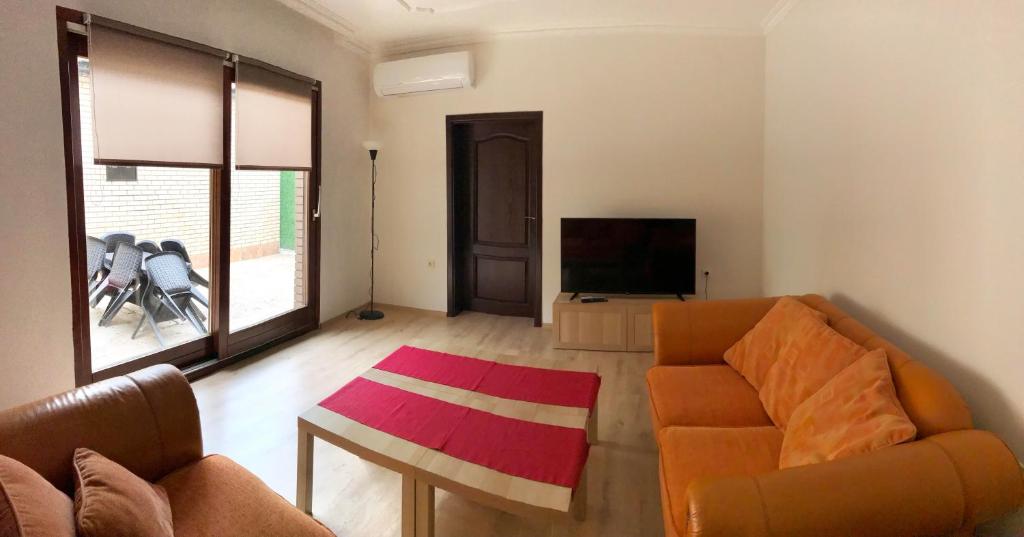 a living room with a couch and a television at Home Base Apartments in Skopje