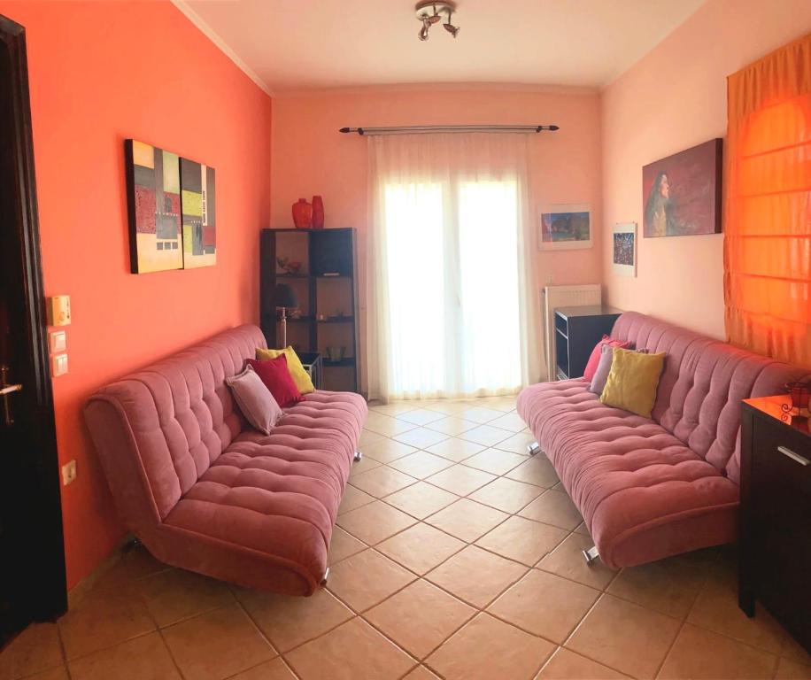 een woonkamer met twee rode leren banken bij Filis mare apartment in Xylokastron