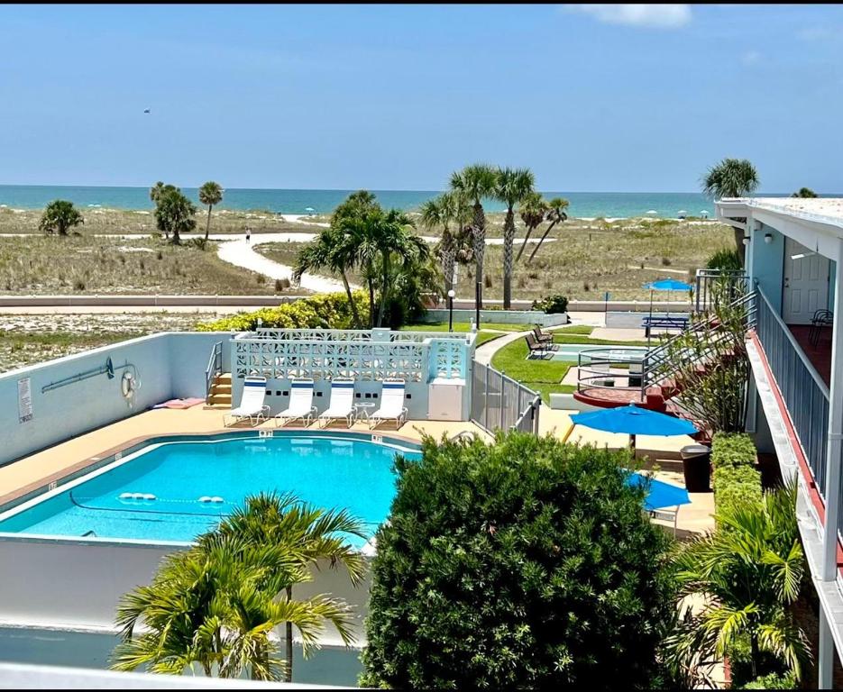 a view of the pool and beach from the balcony of a resort at Beachside Resort Motel in St Pete Beach