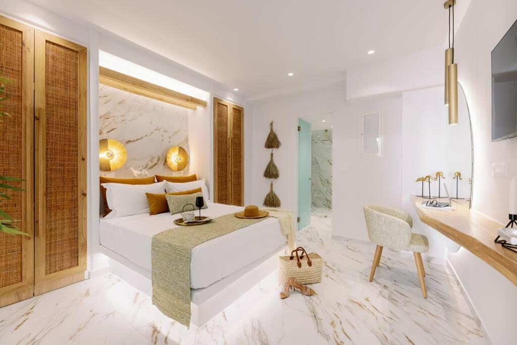 1 dormitorio con 1 cama blanca grande y escritorio en Venus Suite with Hot Tub, en Agios Prokopios