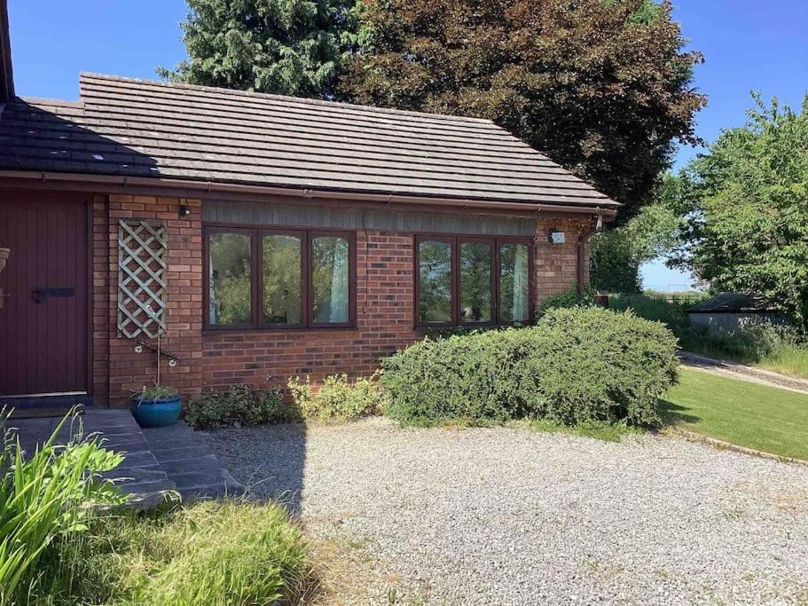 a small brick house with a lot of windows at The Annex at The Croft in Kingsley