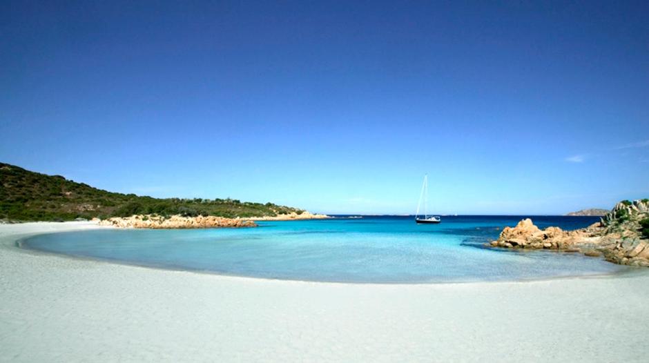 a small beach with a boat in the water at villa fronte mare in Cannigione