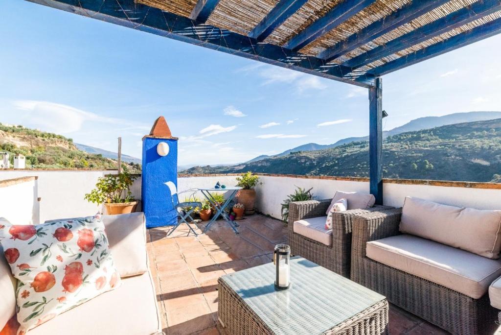 un patio con muebles y vistas al agua en Casa Buena Vista near Granada, en Albuñuelas