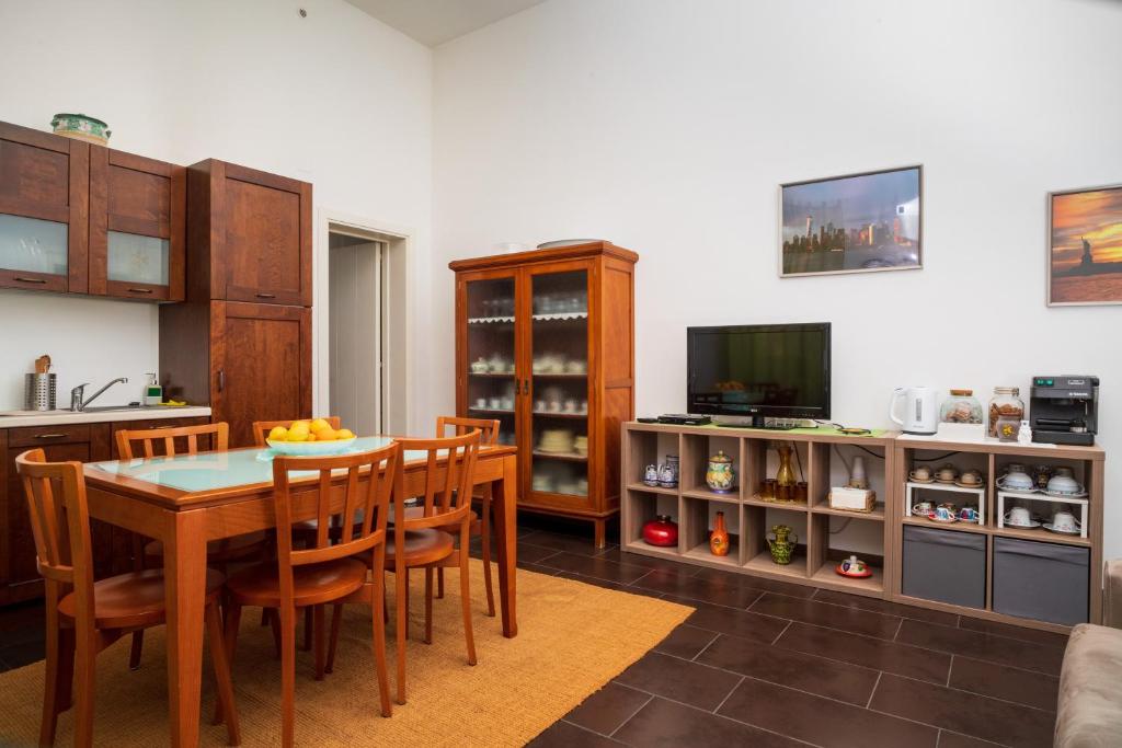 une cuisine avec une table et des chaises ainsi qu'une télévision dans l'établissement Antico Borgo, à Catane