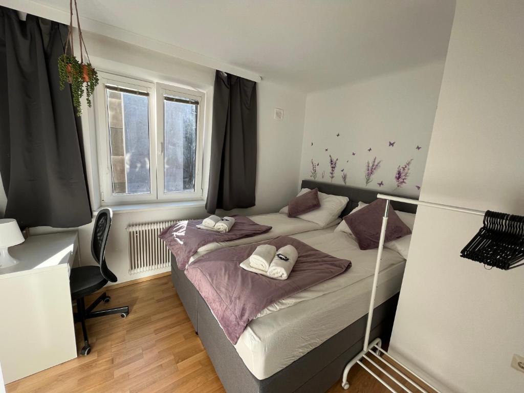 1 dormitorio con 2 camas, escritorio y ventana en *Luxurious and Spacious family apartment*, en Viena