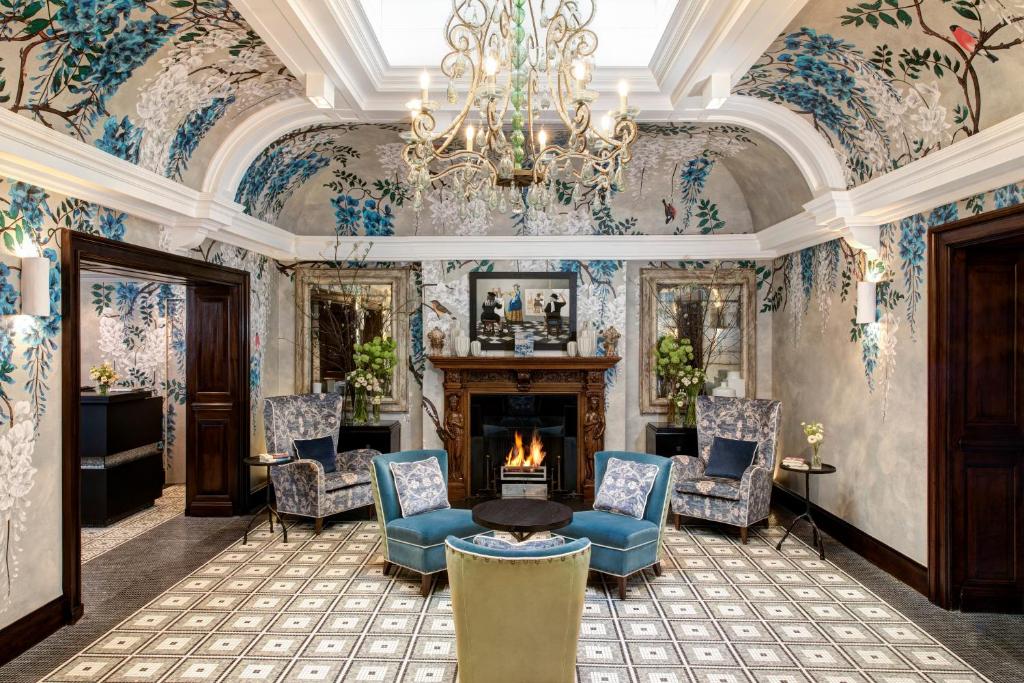 a living room with a fireplace and floral wallpaper at Brown's Hotel, a Rocco Forte Hotel in London
