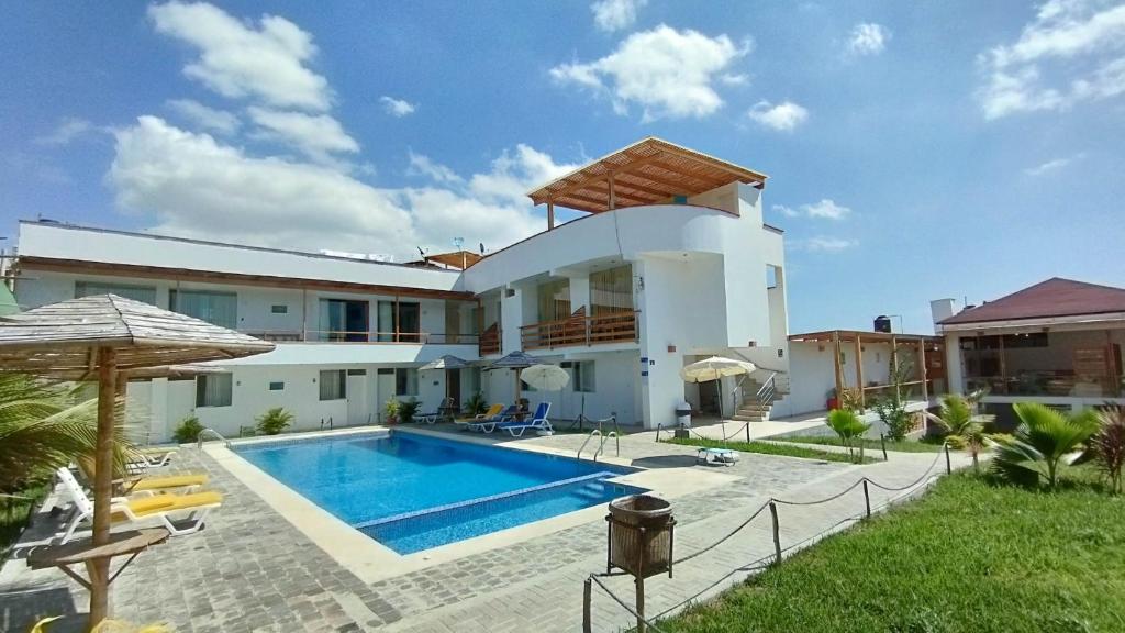een villa met een zwembad voor een huis bij Prim Hotel Vichayito in Vichayito