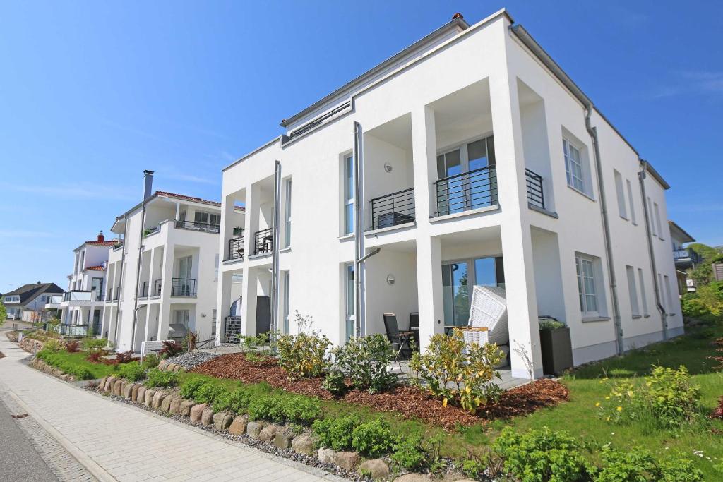 a row of white houses on a street at Villa Antje - Feirenwohnung 01 in Göhren