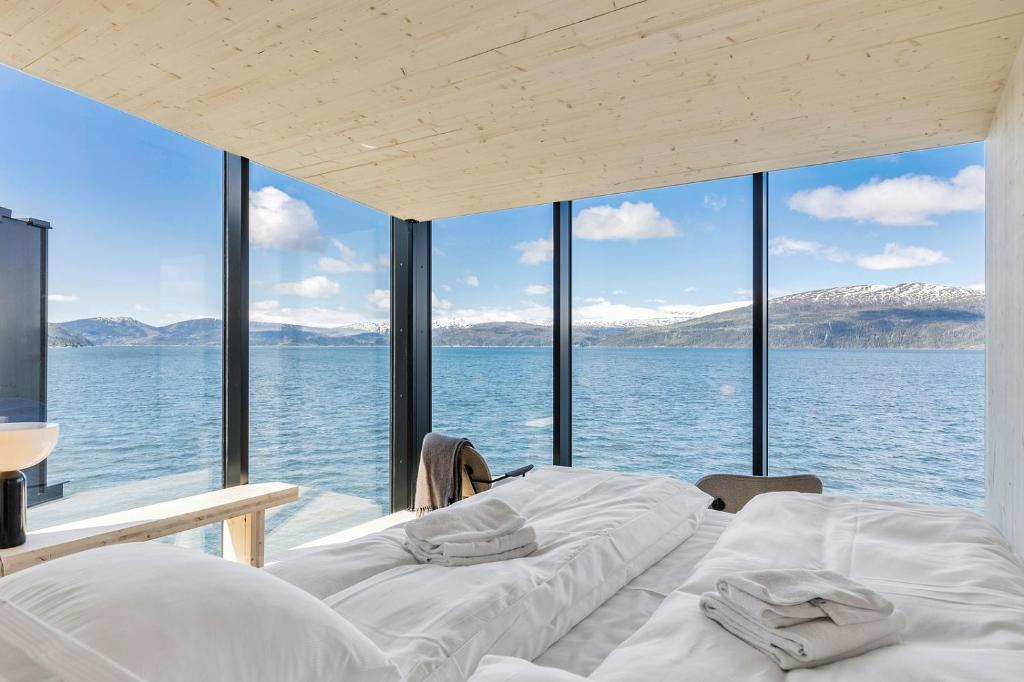 2 Betten in einem Zimmer mit Blick auf das Wasser in der Unterkunft Yttervik in Skamdal