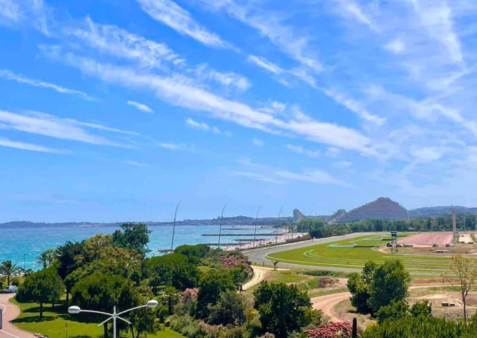 - une vue sur un parc avec l'océan en arrière-plan dans l'établissement Studio avec vue panoramique mer hippodrome, à Cagnes-sur-Mer