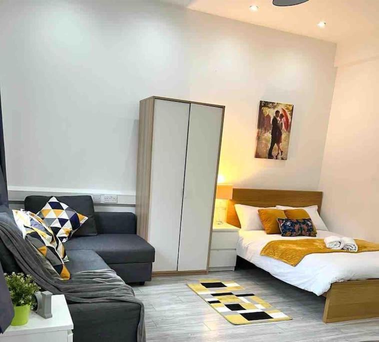 a living room with a bed and a couch at Comfortable flat in Central London in London