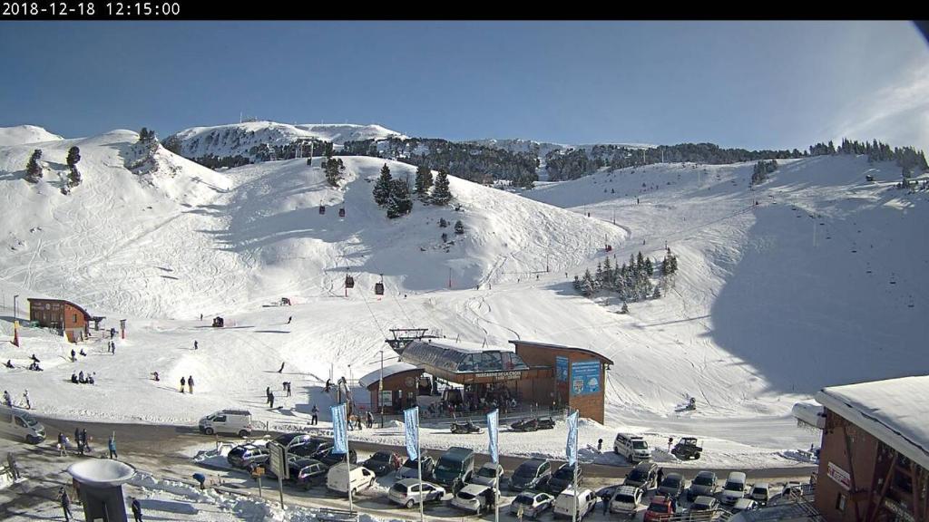 a snow covered mountain with a ski slope with cars parked at CHAMROUSSE T2 Sud Ski Rando et Vtt aux pieds Les balcons du Recoin in Chamrousse