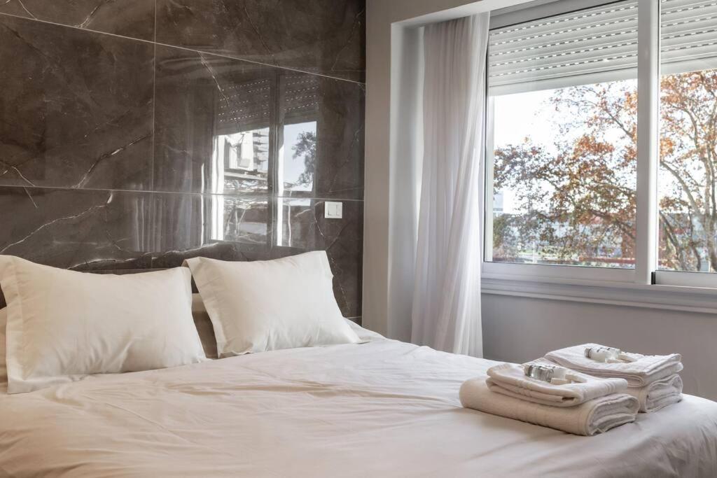 Schlafzimmer mit einem weißen Bett und einem Fenster in der Unterkunft Libertador 774 III by depptö in Buenos Aires