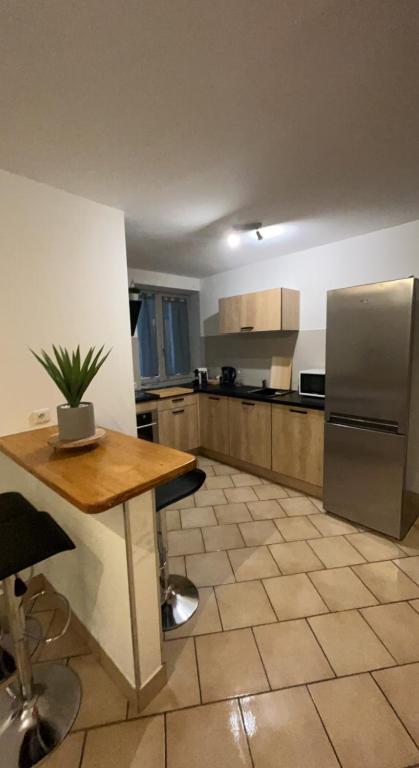 une cuisine avec une table et un réfrigérateur dans l'établissement Maison de village, à Meysse