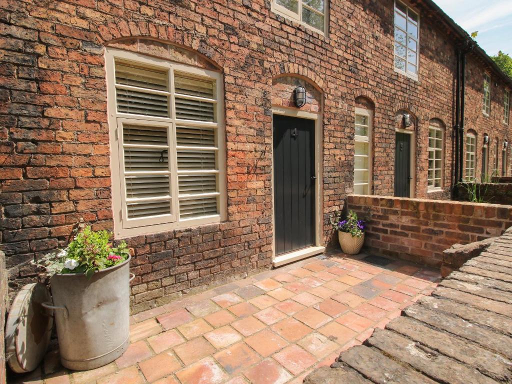a brick building with a door and two potted plants at Number 4 in Telford