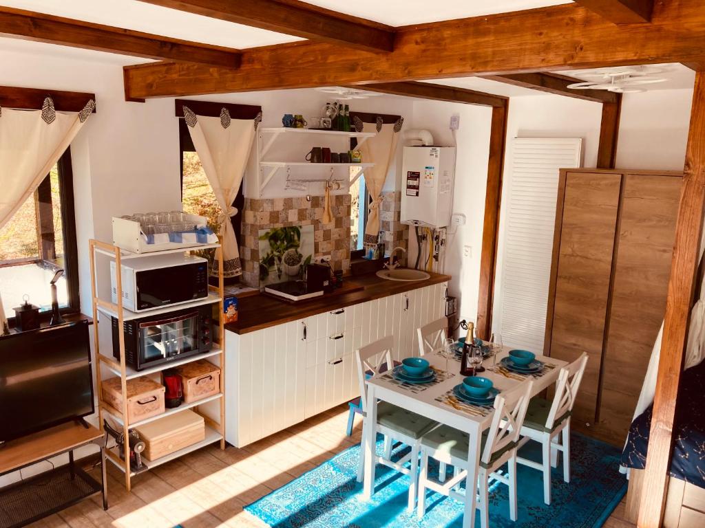uma cozinha com mesa e cadeiras num quarto em Studio Mirage@Snow Residence (ski & forest) em Azuga