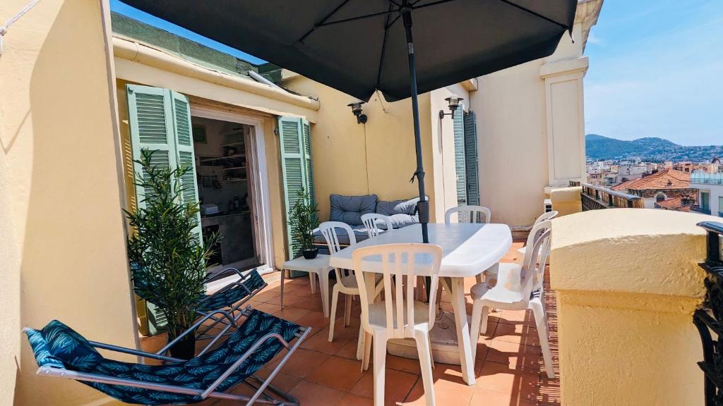 un balcon avec une table, des chaises et un parasol dans l'établissement 