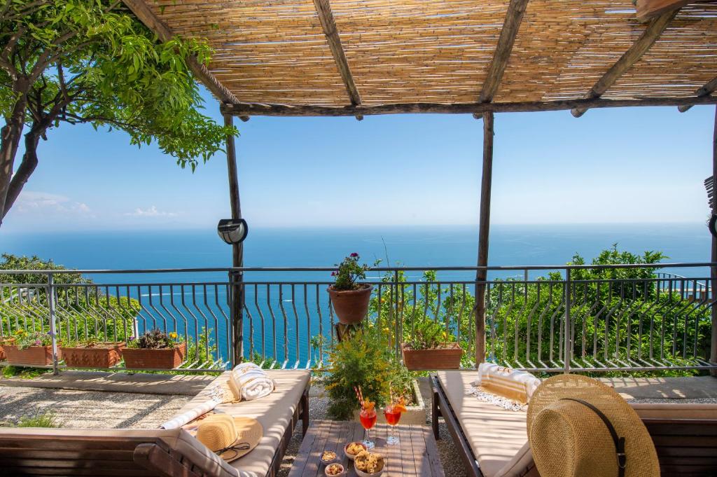 un patio con mesa, sillas y el océano en Amalfi Residence, en Conca dei Marini