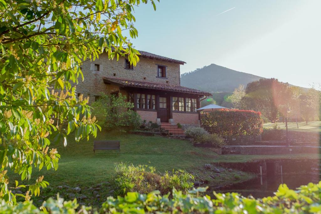 een gebouw met een bank ervoor bij El Molino de Bonaco in San Vicente de la Barquera