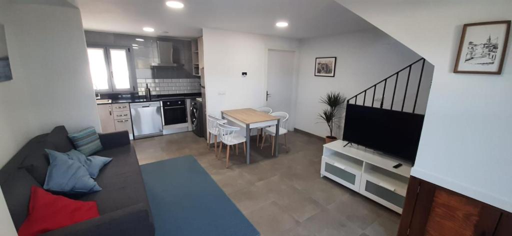 a living room with a couch and a table and a kitchen at El Molino 2 in Muros de Nalón